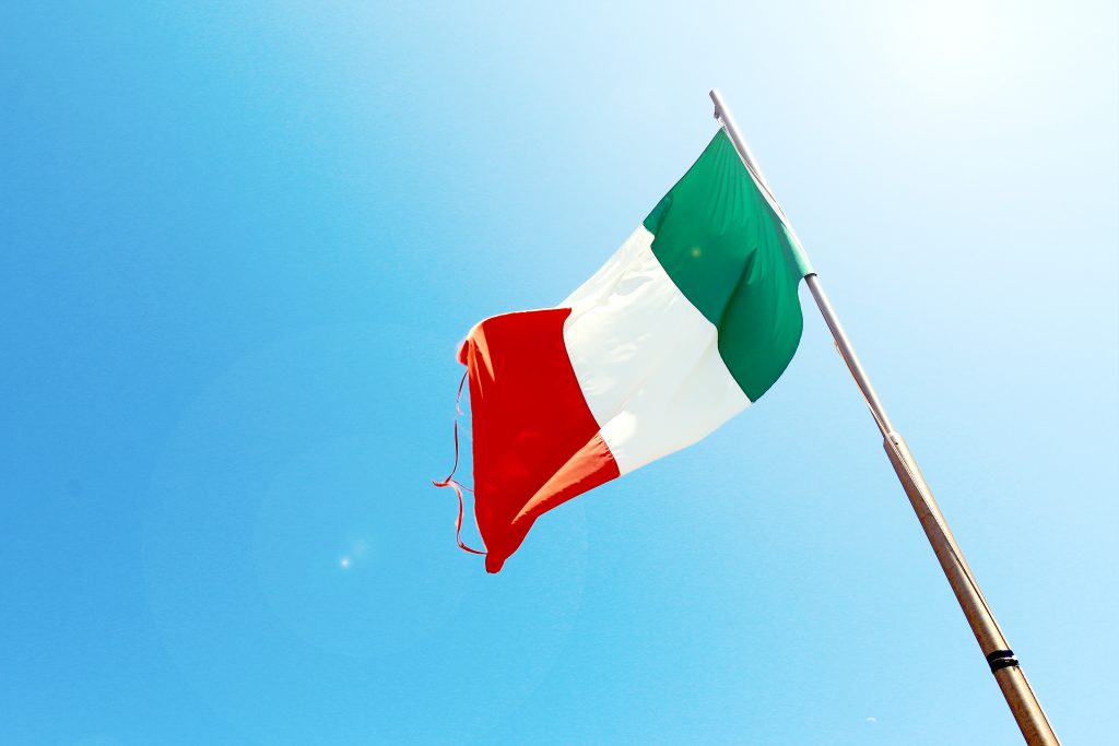 Italienische Flagge auf Stange vor blauem Himmel