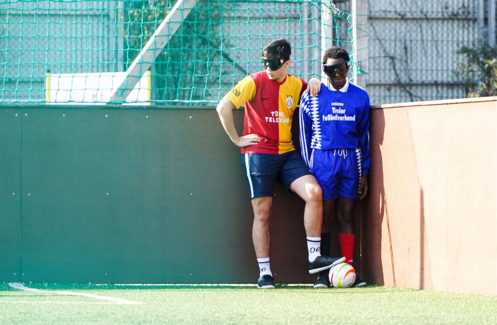 Mustafa und Pauline stehen in der Ecke des Spielfeldes und bereiten sich auf einen Eckstoss vor. 